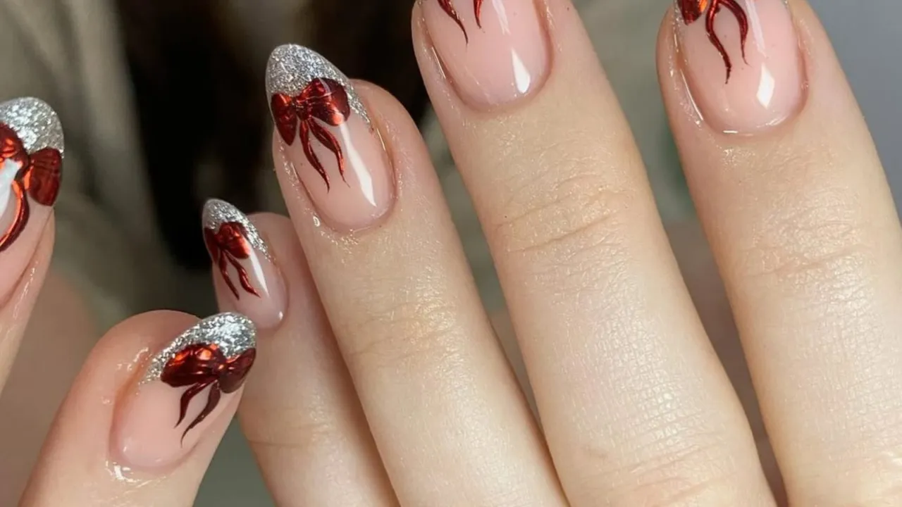 Christmas nails with red chrome bows and silver glitter tips