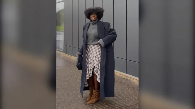 Woman in a long charcoal coat, grey knit and plaid ruffle skirt, cold weather dinner outfit
