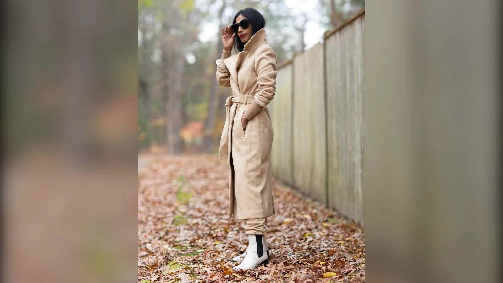 Petite woman in a belted camel wrap coat and white boots, cold weather outfit for petite women