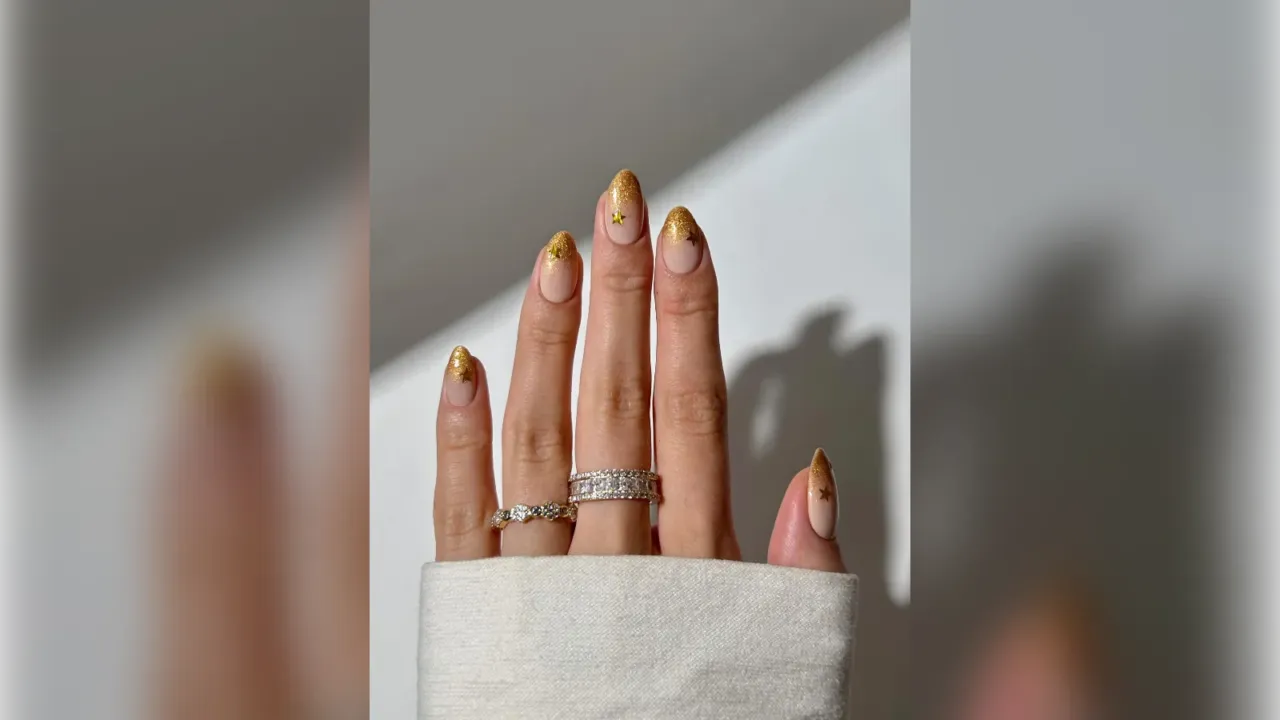Gold glitter tip New Years nails on almond nails with rings