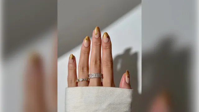 Gold glitter tip New Years nails on almond nails with rings