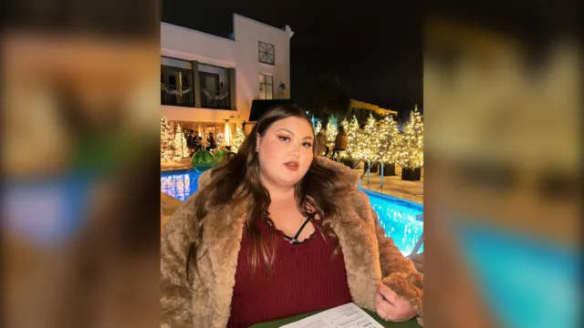Plus size woman in a fuzzy brown teddy coat and burgundy knit at a holiday dinner, plus size cold weather outfit
