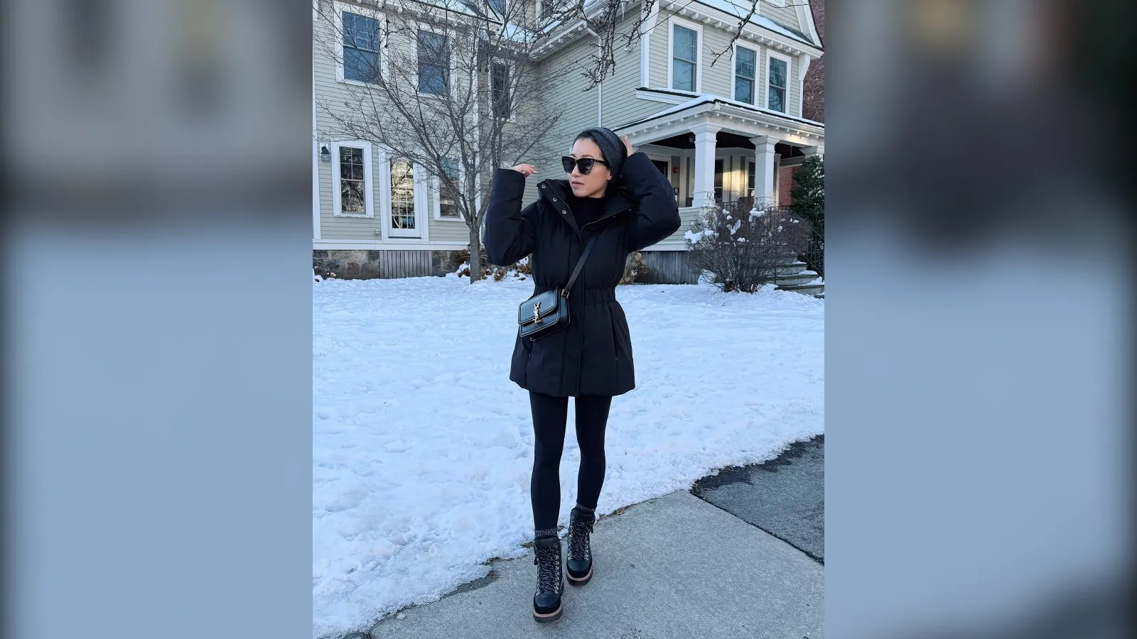 Woman in a black puffer coat and waterproof boots on a snowy street