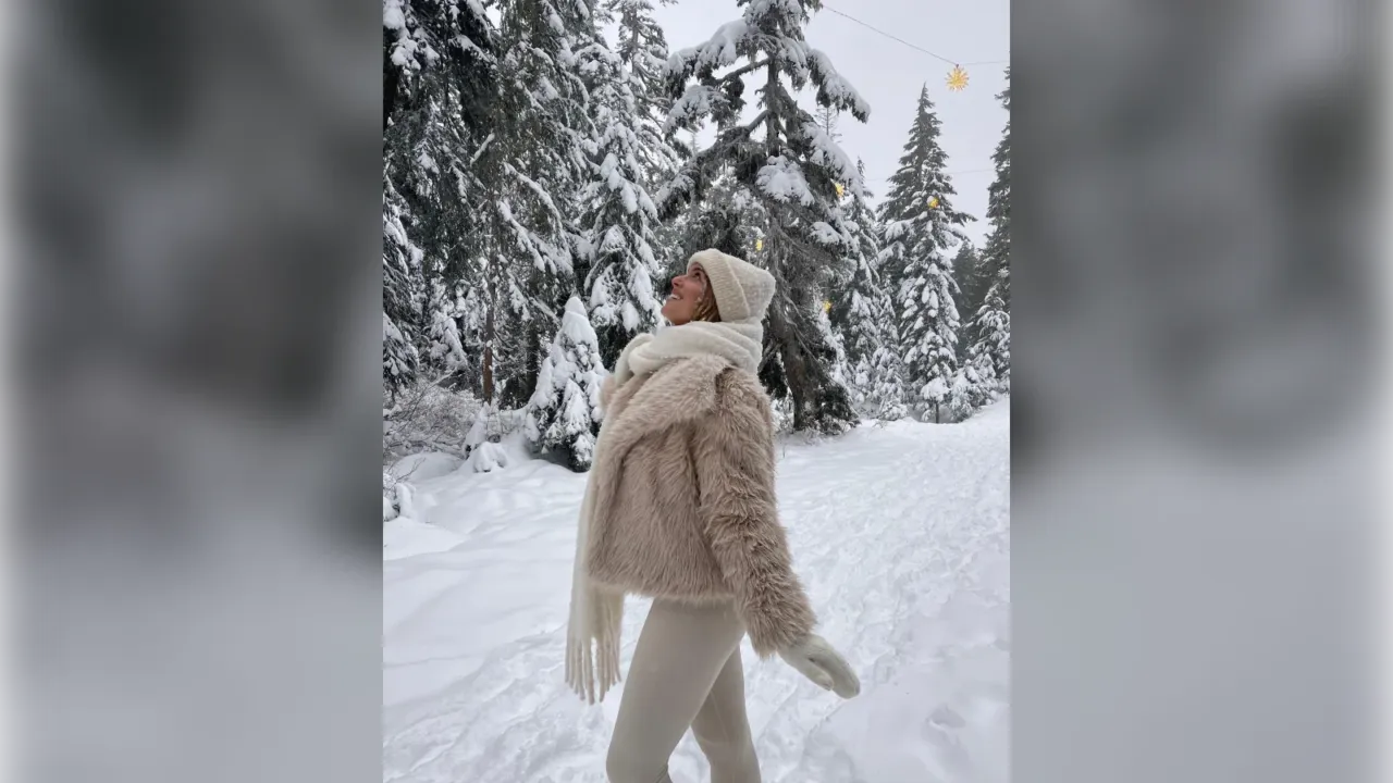 Woman in a beige teddy jacket, cream scarf and leggings in the snow