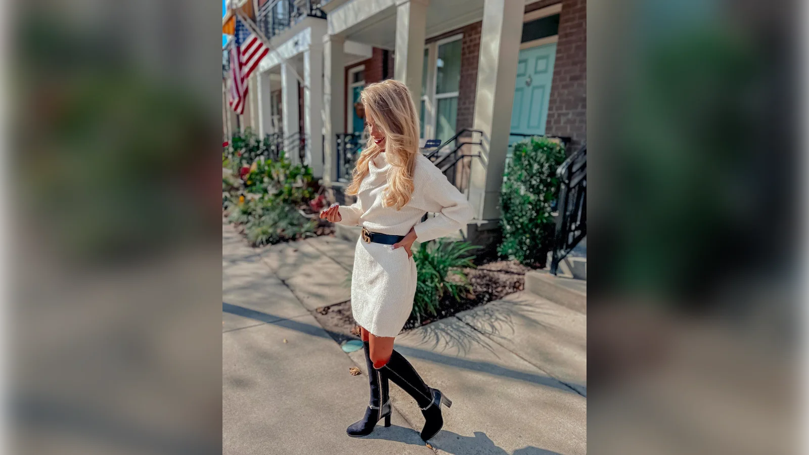 White cable knit sweater dress with a black belt and black knee boots
