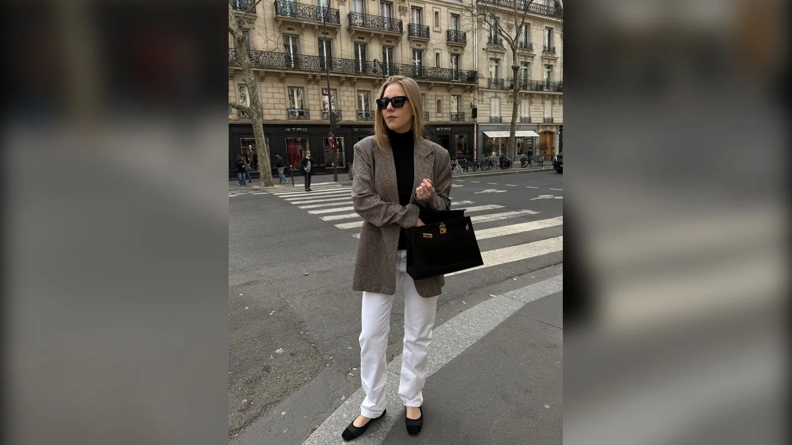 Woman in a black turtleneck, brown blazer and white jeans in the city