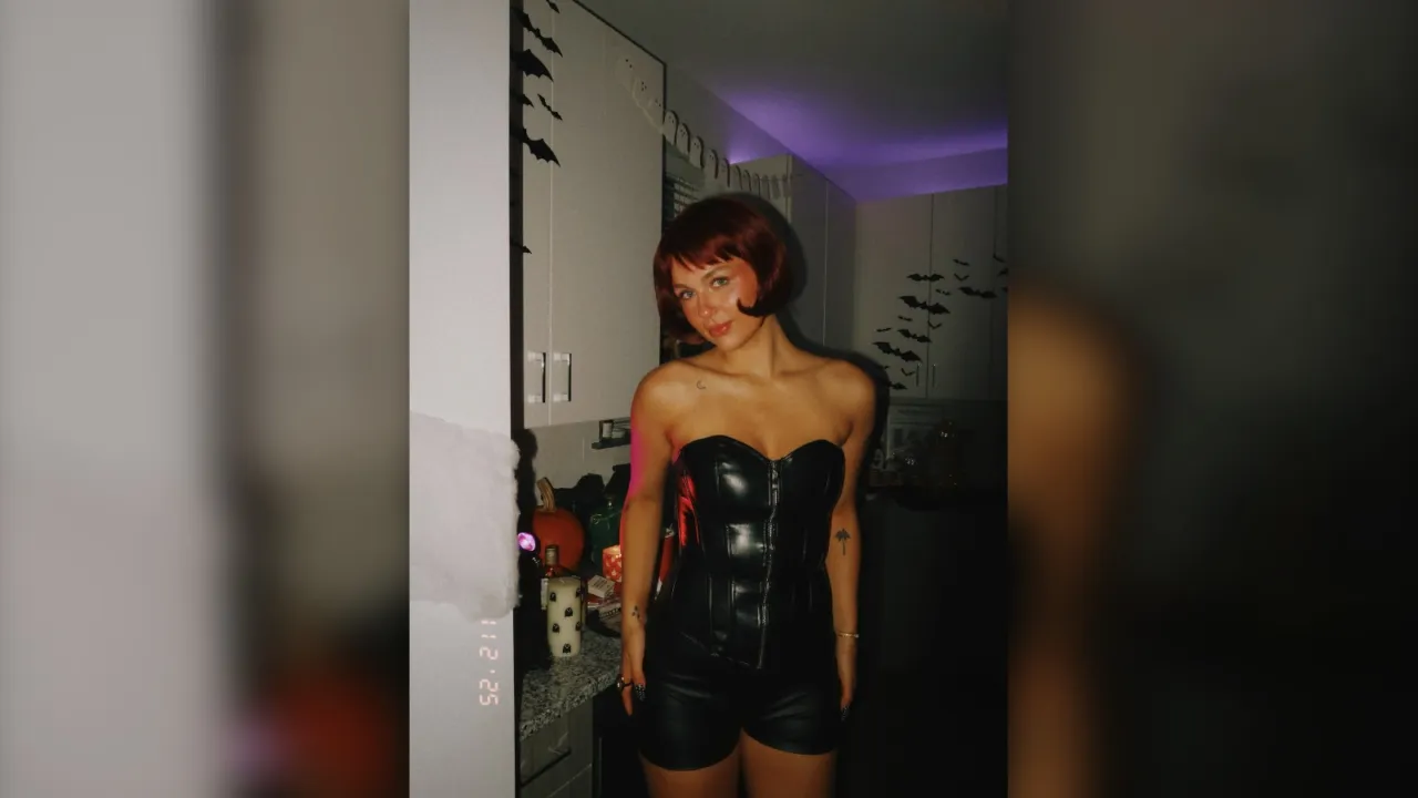 Woman in a black leather corset top and shorts for a winter date night