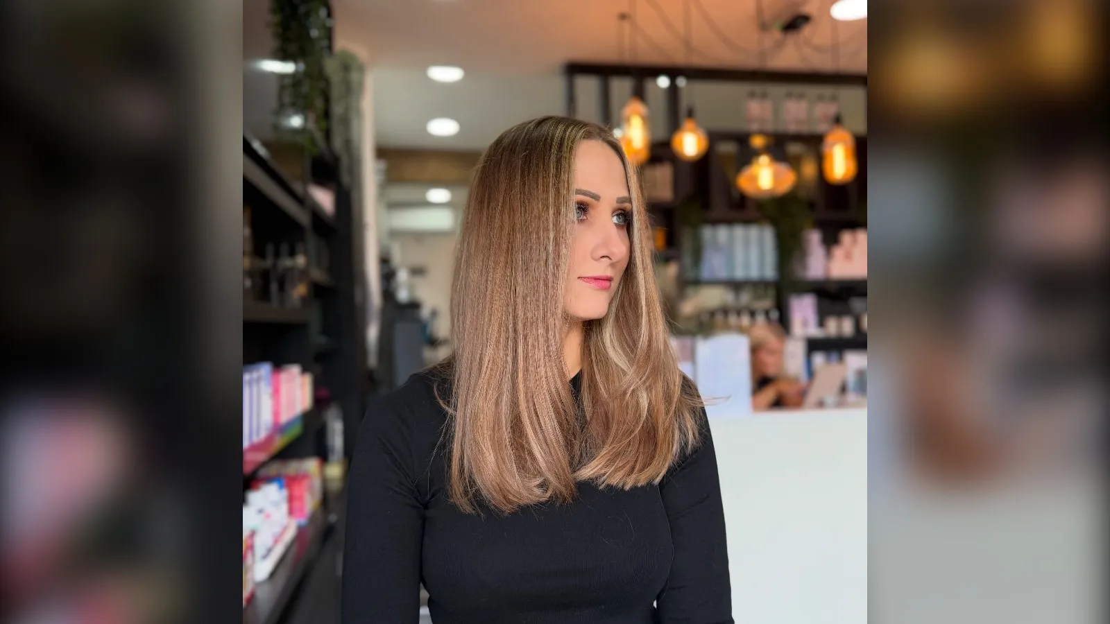 Woman with a glossy light brown blowout in a London hair salon