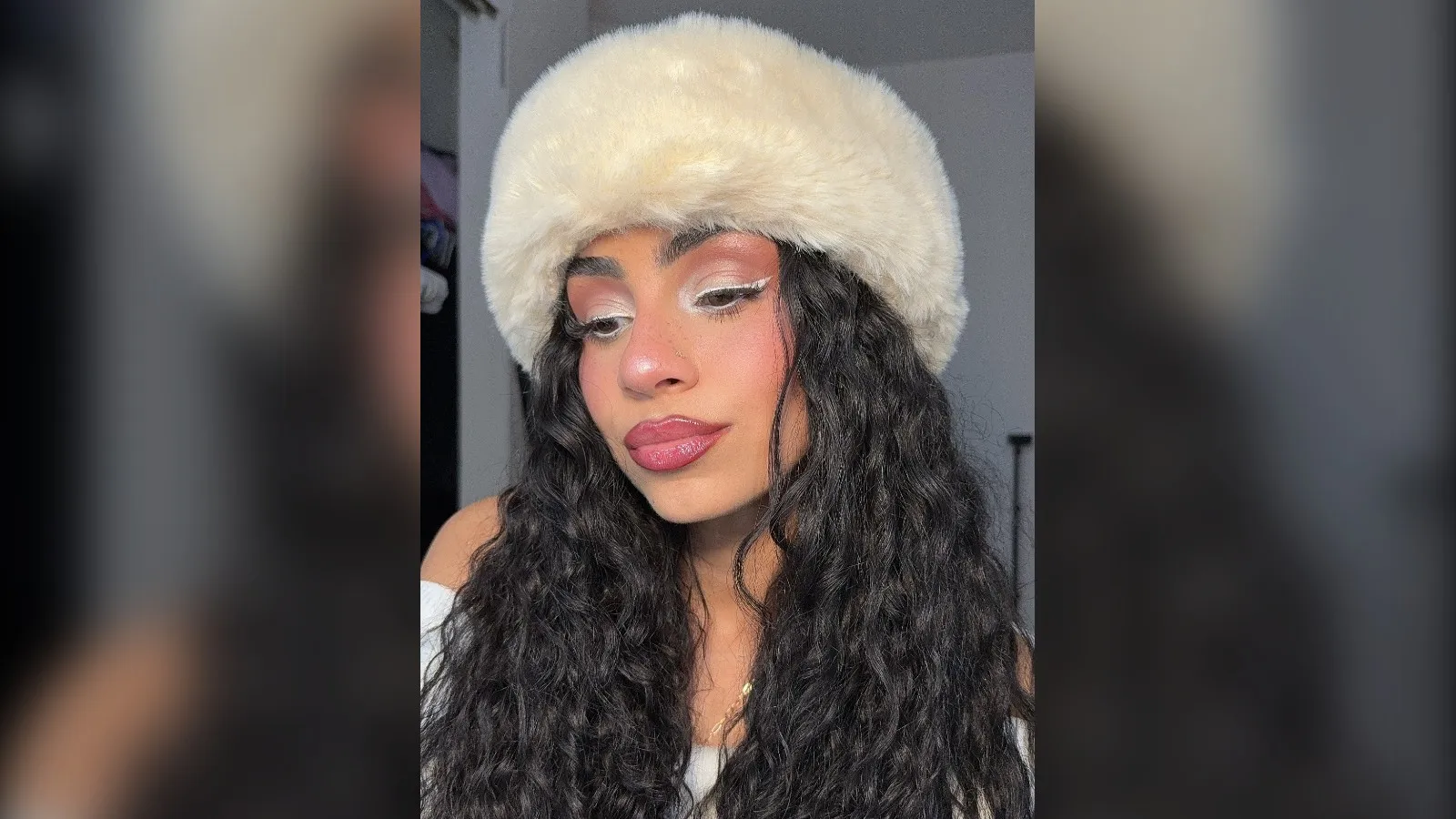 Woman with frosty white liner, rosy cheeks and a cream fur hat, winter makeup look